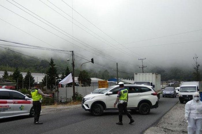 Personel Satlantas Polres Tanah Karo menghadang pengendara yang hendak memasuki wilayah Kabupaten Karo (27//5/2020)