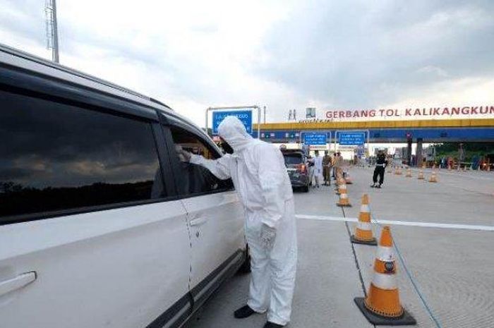 Petugas memeriksa suhu tubuh pengendara di gerbang Tol Kalikangkung, Kecamatan Ngaliyan, Sabtu (30/05/2020).