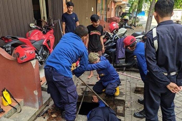 Tim rescue Damkar evakuasi kunci motor Fikri yang tercebur di gorong-gorong Cengkareng, Jakarta Barat Minggu (31/5/2020).