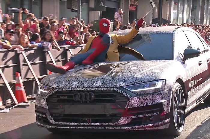 Spider-Man duduk di atas salah satu mobil merek pabrikan Jerman, Audi