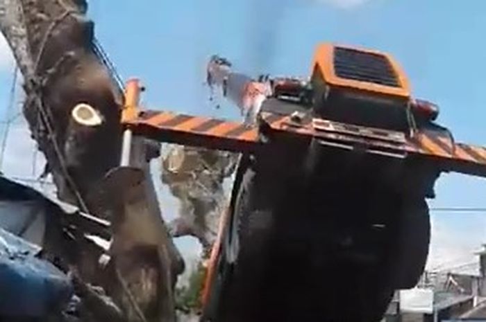 Truk Crane terjungkir saat mencoba mengangkat potongan pohon