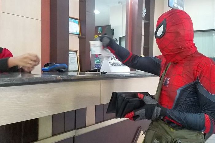 Pria berkostum Spiderman membayar pajak mobilnya di Samsat Madiun. 