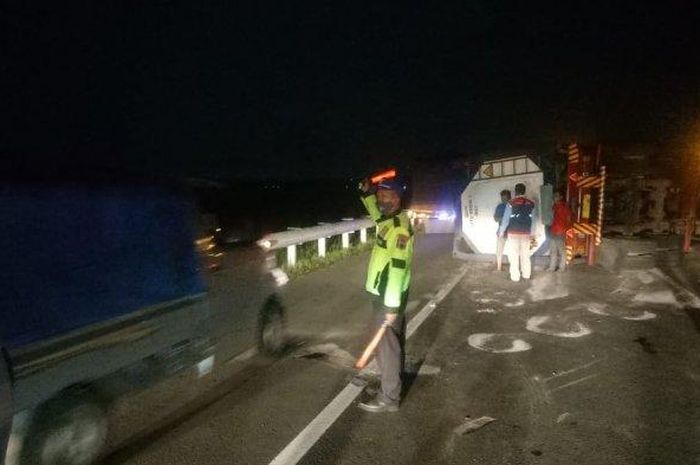Petugas Satlantas Polres Pekalongan mengatur arus lalu lintas di lokasi truk trailer Isuzu yang terguling di Jalan Tol Pekalongan-Batang KM 334+600, Kamis (04/06/2020)