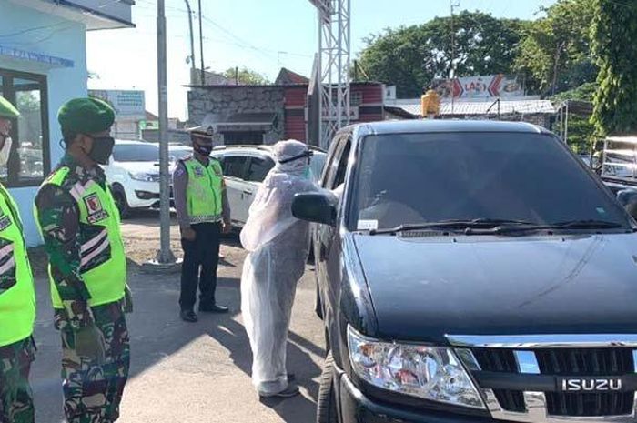 Petugas memeriksa sebuah mobil yang memasuki wilayah Kabupaten Lamongan, Jumat (5/6/2020).