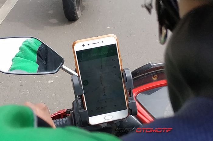 Ojek online menggunakna GPS pada ponsel saat berkendara mengantar dan menjemput penumpang. ()