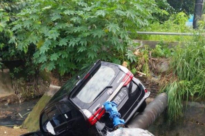 Toyota Avanza terjungkal ke kali usai terbang dari atas jalan hingga menindih pipa air 