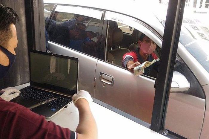 Seorang warga mengambil SIM yang ditilang menggunakan layanan drive thru Kejaksaan Negeri Bandar Lampung, Rabu (10/6/2020).