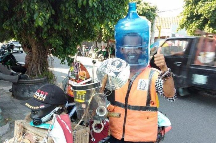 Ali Akbar (52), Ali Topan  atau Ali galon, menggunakan galon sebagai pengganti masker saat mengatur lalu lintas