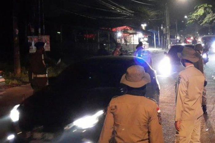 Aparat Satuan Polisi Pamong Praja (Satpol PP) Tangerang Selatan (Tangsel) menggelar razia Pembatasan Sosial Berskala Besar (PSBB) di depan Balai Kota Tangsel, Jalan Maruga, Ciputat, pada Selasa tengah malam (16/6/2020).