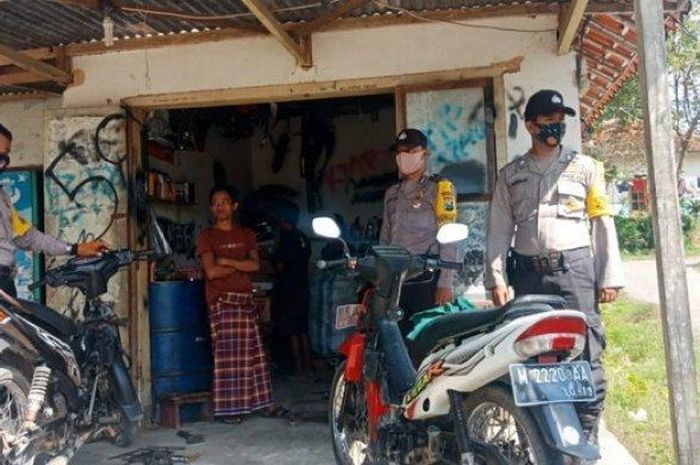 Personel Patroli Polsek Proppo Pamekasan, Aipda Farid bersama rekan kerjanya saat mendatangi pemilik bengkel motor di Desa Toket, Kecamatan Proppo, Minggu (21/6/2020).  