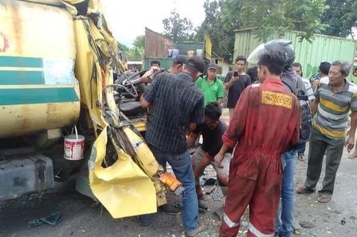 Warga saat berupaya mengevakuasi supir truk tangki yang terjepit di dekat setir mobil setelah menabrak bak truk dalam posisi mundur di Jalan Soekarno Hatta Palembang, Selasa (23/6/2020).