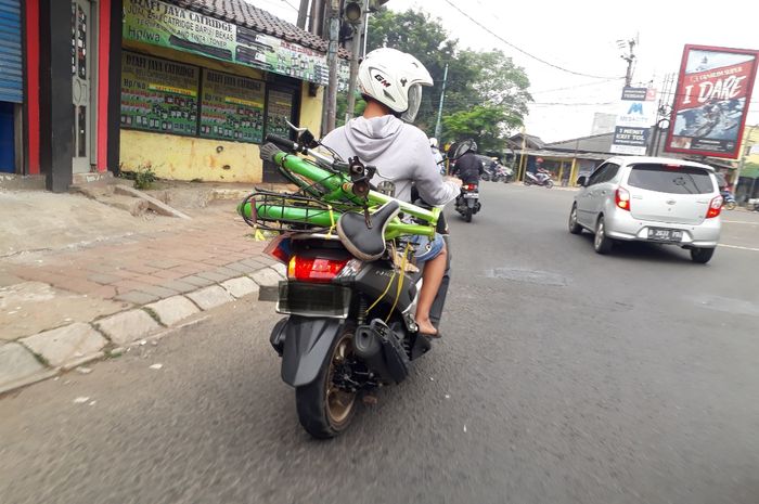Ilustrasi pengendara yang membawa sepeda