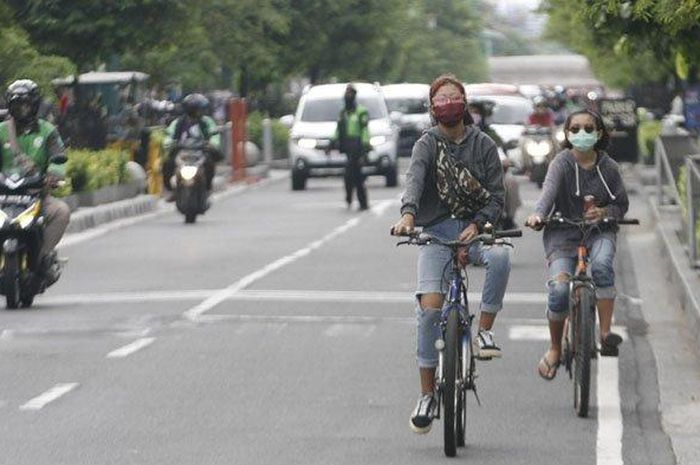 Pesepeda menggunakan masker saat beraktifitas di kawasan Malioboro, Kota Yogyakarta, Senin (8/6/2020).