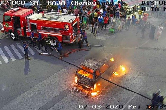 Petugas pemadam kebakaran menyemprotkan air ke angkutan umum, Jumat (3/7/2020). 