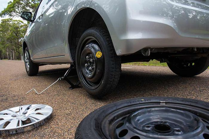 Ilustrasi mengganti ban yang kempis dengan ban cadangan space saver