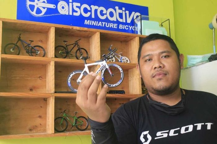 Yudi Hermawan, salah satu pemuda yang tergabung dalam Aiscreative Miniature Bicycle menunjukkan miniatur sepeda buah tangan mereka.
