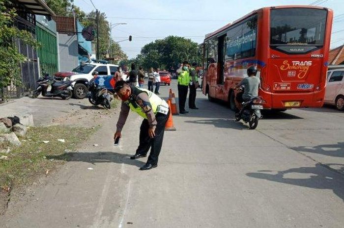 Petugas Satlantas Polrestabes Semarang saat mengamankan lokasi kejadian terserempetnya seorang pengedara sepeda motor hingga tewas di Jalan Citarum Raya Semarang, Jumat (10/7/2020).  