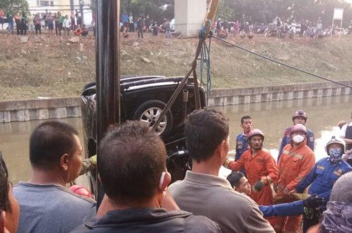 Personel Sudin PKP Jakarta Timur saat proses evakuasi mobil yang tercebur ke aliran Kalimalang, Duren Sawit, Jumat (10/7/2020).