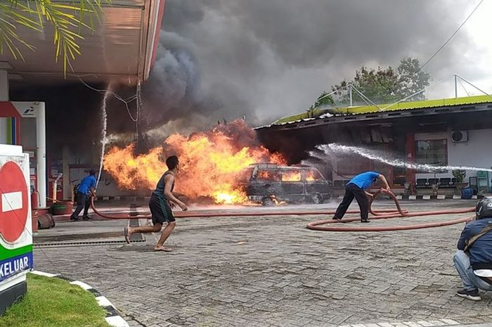 Petugas pemadam kebakaran dan petugas SPBU Desa Larangan Badung, berusaha memadamkan api yang membakar mobil bermuatan bensin.(KOMPAS.COM/TAUFIQURRAHMAN) 