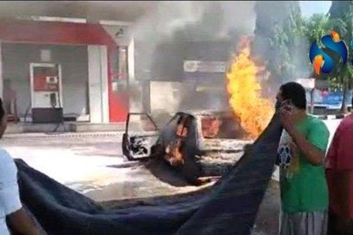 Petugas SPBU bersama warga mencoba memadamkan api yang membakar mobil Mazda di Desa Sotaber, Kecamatan Pasean, Kabupaten Pamekasan, Madura, Rabu (22/7/2020).