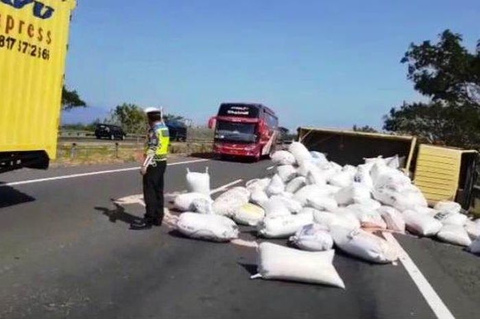 Polisi mengatur lalu lintas di lokasi kecelakaan truk bermuatan gabah yang terguling di Tol Cipali km 154, Majalengka, Jawa Barat, Sabtu (25/7/2020) siang. 