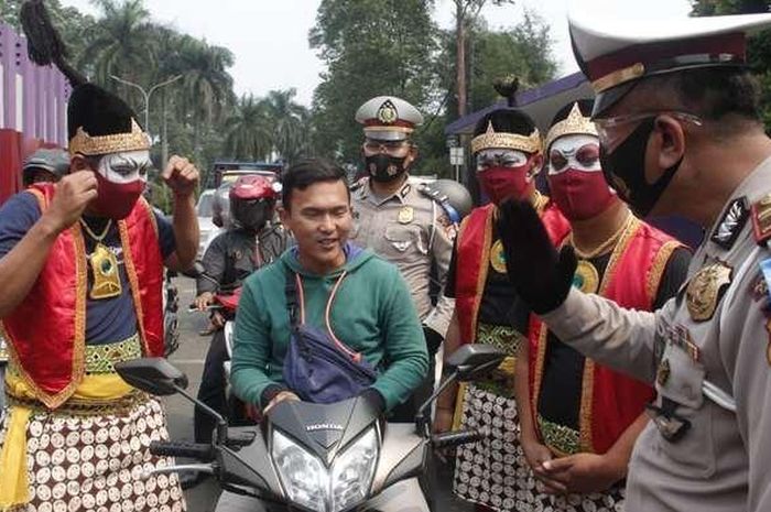Personel Satlantas Polresta Tangerang berdandan menjadi tokoh punakawan saat memberikan edukasi kepada masyarakat pengendara.