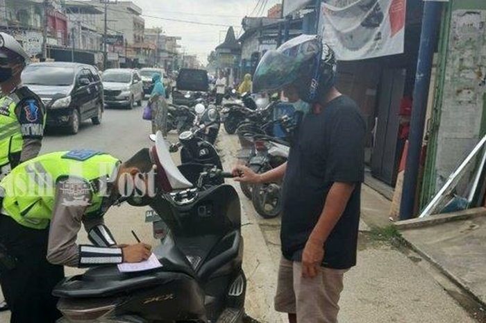 Personel Satlantas Polres Tanbu tengah menindak pengendara yang melanggar aturan lalu lintas.