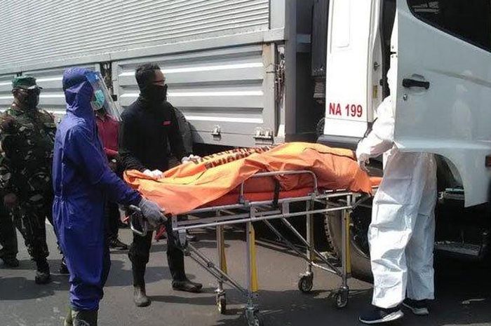 Petugas Linmas Surabaya evakuasi jenazah korban sopir truk box yang tewas di truknya yang diparkir di bahu Jalan Karangpoh, Tandes, Surabaya, Rab (29/7/2020). 