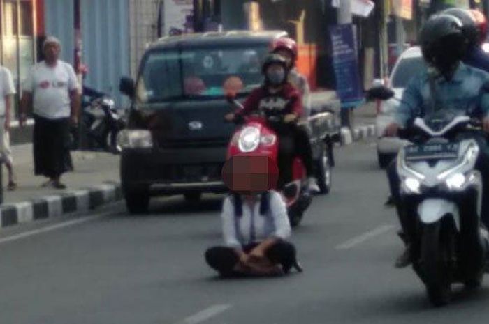 Perempuan yang diduga ODGJ duduk bersila di tengah Jalan Dhoho Kota Kediri yang padat arus lalu lintasnya, Senin (3/8/2020). 