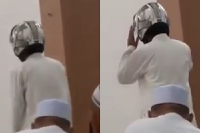 Seorang bapak-bapak memakai helm didalam masjid