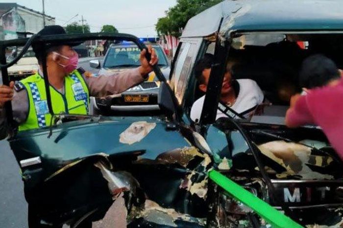Polisi dan warga berusaha membantu Teguh Haryadi yang terjepit, seusai mobilnya menabrak truk, di Jalan Raya Ngantru, Tulungagung, Selasa (4/8/2020). 