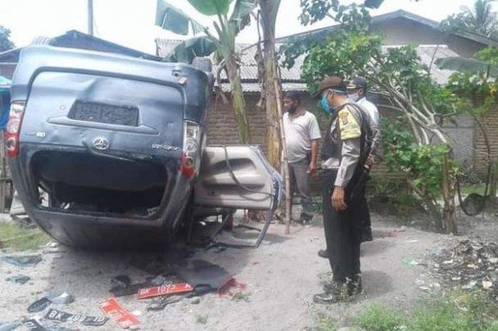 Toyota Avanza mobil operasional BNN Deliserdang yang dirusak warga tampak dalam keadaan terbalik di Desa Regemuk Kecamatan Pantai Labu Kabupaten Deliserdang Rabu, (5/8/2020). 