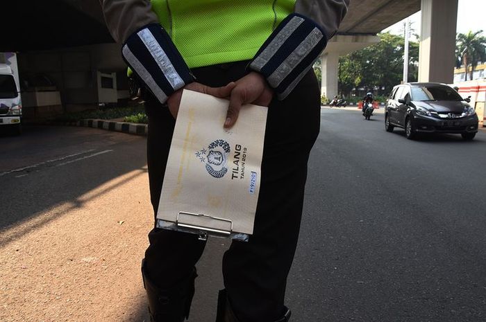 Polantas memantau kendaraan saat hari pertama pemberlakuan kembali kebijakan ganjil-genap kendaraan di Jalan Gatot Subroto, Jakarta, Senin (3/8/2020). 