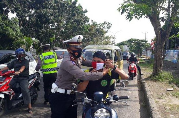 Personel Satlantas Polres Bangka bagi-bagi masker merah putih kepada pengguna jalan dalam rangka menyambut datangnya HUT Kemerdekaan RI ke-75, Selasa (11/08/2020) di Sungailiat Bangka.