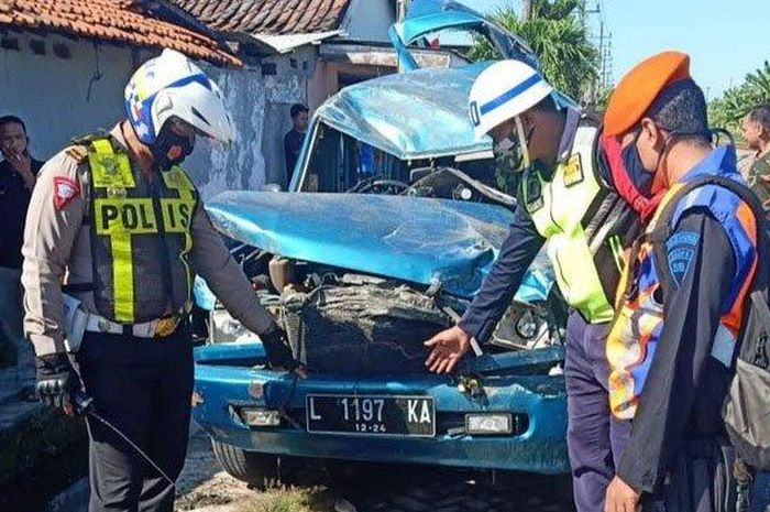 Petugas memerika mobil kijang yang tertabrak kereta api di Gilang Taman Sidoarjo  