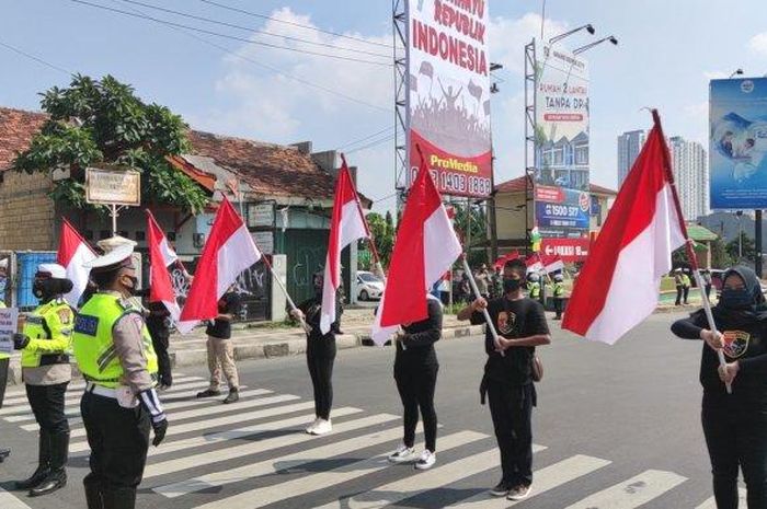 personel TNI dan Polisi Kibarkan Bendera Merah Putih di Simpang Margonda