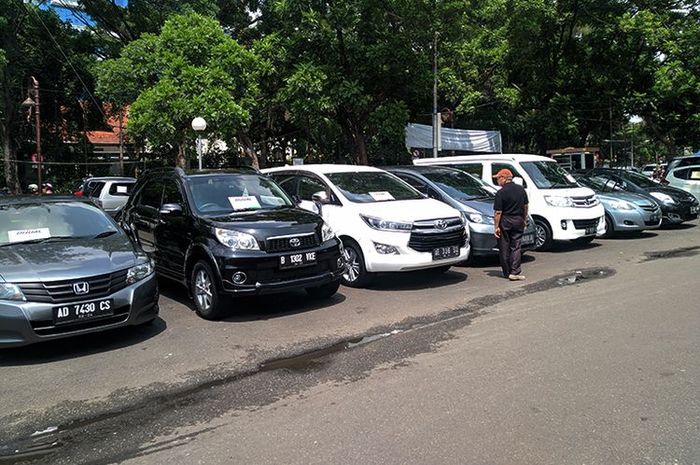 Seorang pengunjung melihat deretan mobil bekas yang dipajang di bursa mobil Sriwedari, Solo, Jawa Tengah (Jateng), Minggu (15/12/2019).