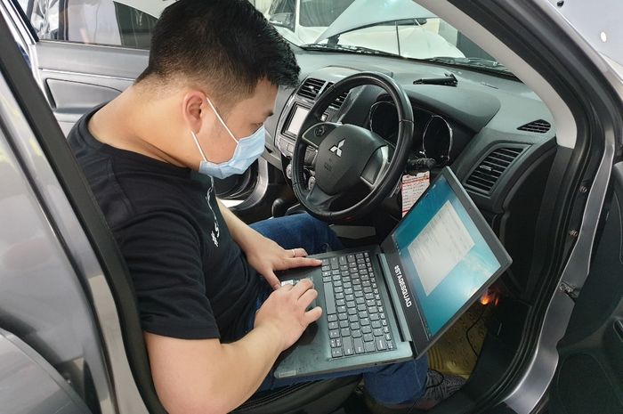 Seorang teknisi sedang melakukan remap ECU mobil customer