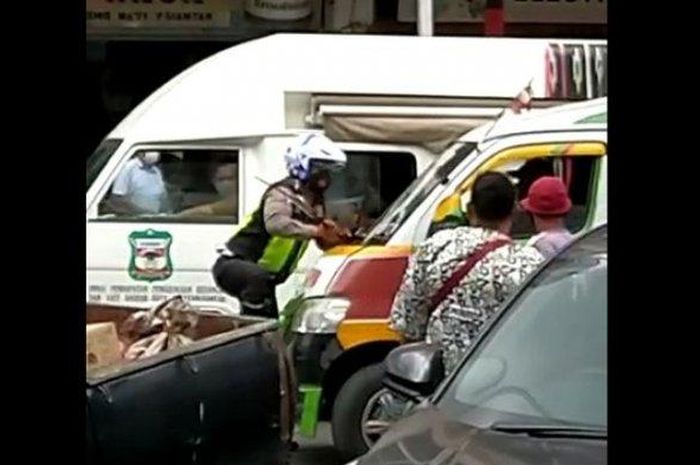 Bripka Panal Simarmata dari Polres Pemantangsiantar nemplok di depan angkot