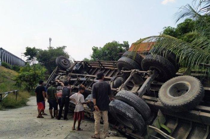 TERGULING: Sebuah truk tronton pengangkut keramik dan garmen terguling di Jalan Raya Pantura Kendal -Jakarta, Senin (21/9/2020). 