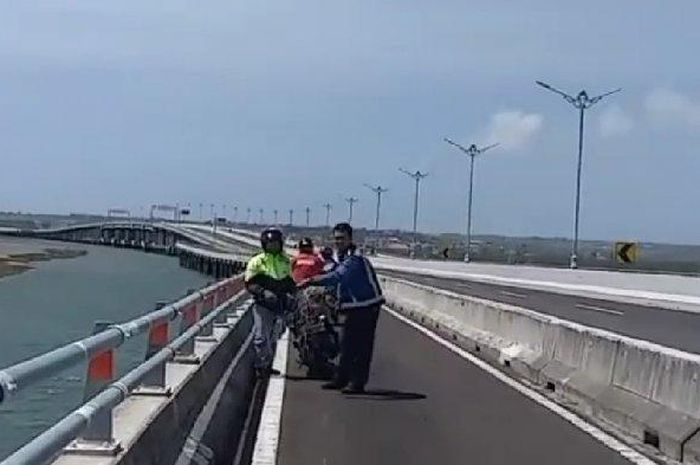 Petugas Jasamarga terlihat menggulung tali layangan yang melintang di jalur pemotor Tol Bali Mandara, Selasa (6/10/2020). 