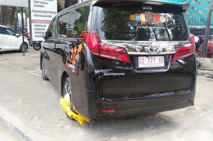 Toyota Alphard yang digembok Dishub kota Makassar karena parkir sembarangan