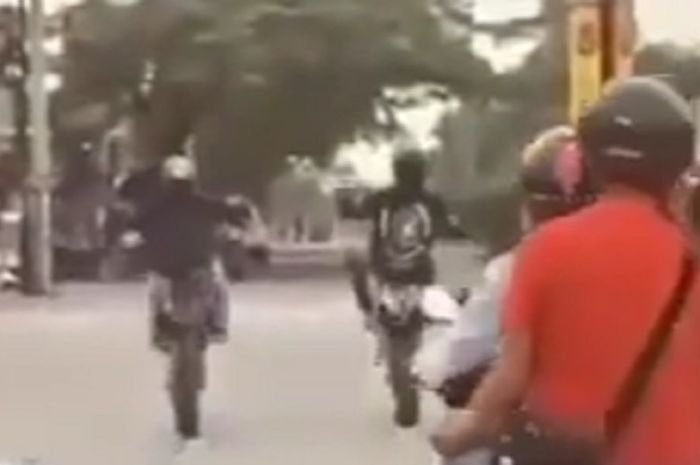 Viral video dua orang pengendara motor trail melakukan aksi wheeli di lampu merah dan ditabrak pemotor lain.