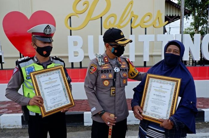 Kapolres Bukittinggi AKBP Dody Prawiranegara memberikan penghargaan kepada Sri Harlina dan Brigadir Hafiz Basari.