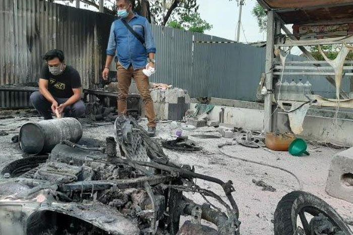 Petugas saat melakukan olah TKP motor yang tinggal rangka akibat terbakar di Jalan dr. Wahidin Sudirohusodo, Gresik, Senin (23/11/2020).  