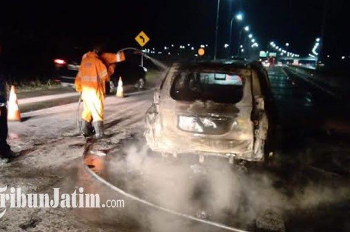 Petugas memadamkan mobil Pajero Sport terbakar di Tol Ngawi Kertosono, di KM 610+900 A, Selasa (24/11/2020) sore.