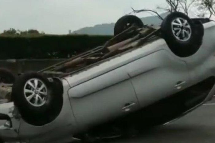 Toyota Avanza rebahan dengan posisi terbalik roda di atas di tol Padaleunyi