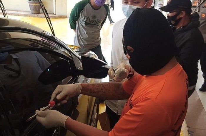 SL, pelaku maling modus pecah kaca memperagakan saat dirinya beraksi