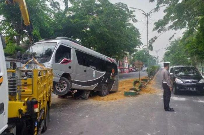 Isuzu Elf dievakuasi usai hajar pembatas jalan Trunojoyo, Patemon, Pamekasan, Madura akibat pecah ban