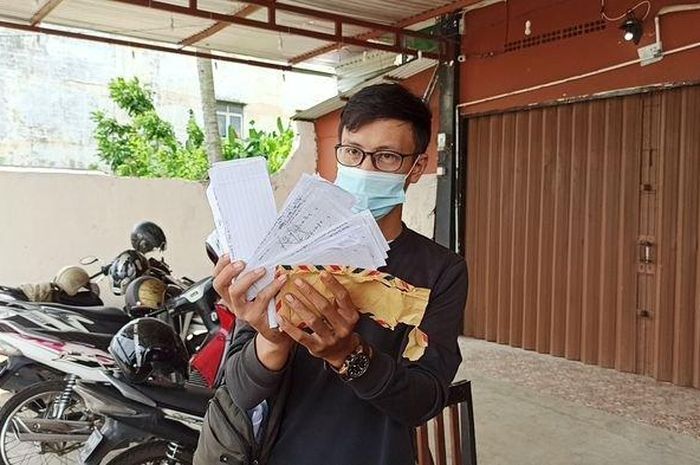 Korban menunjukan amplop yang berisikan kertas senilai 10 juta dari hasil jual motor melalui COD, Minggu (6/12/2020) 